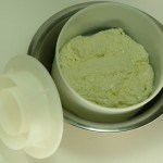 curds in cheese mold with lid removed