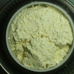 matted cheese curd in mold over drainer