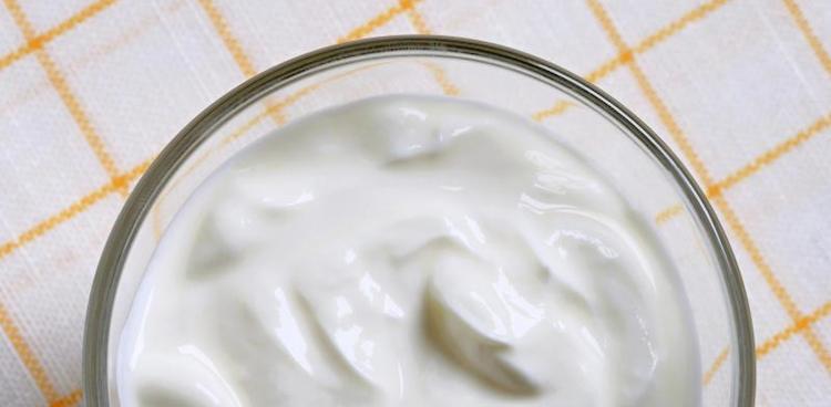 Quark cheese in glass bowl on checkered white and yellow cloth