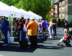 People mill around tents in the street