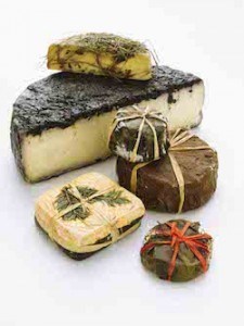 A pile of cheeses wrapped in herbs and flavorings.