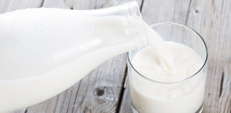 Milk being poured from milk bottle into drinking glass