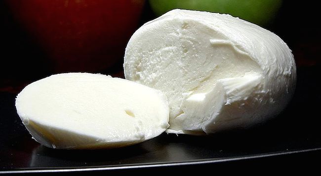 fresh mozzarella with a slice cut from it
