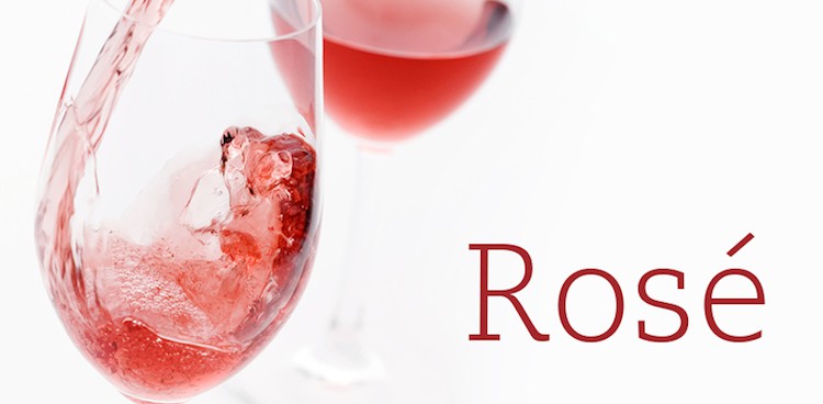 Rosé wine is poured into a clear wine glass