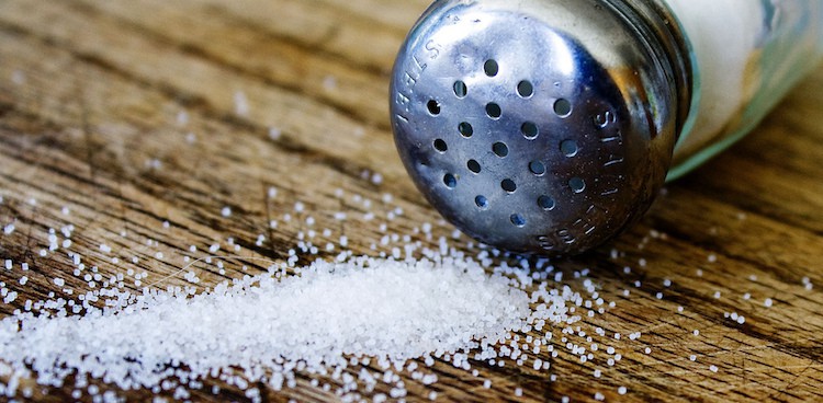 salt spilling from a salt shaker onto a table