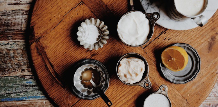 rustic image of metal containers holding buttermilk and buttermilk-containing products on wooden platter