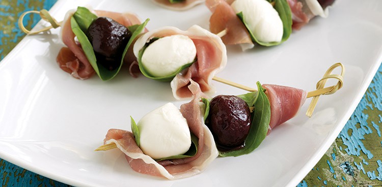 Creamy bocconcini (mini mozzarella balls), pickled sour cherries, herbacious basil, and salty prosciutto alternated on bamboo skewers