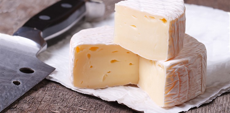 brie-style cheese cut with rind and paste showing