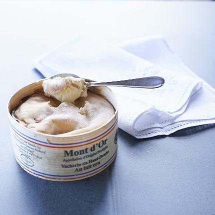 Vacherin Mont d'Or with a spoon being dipped into it