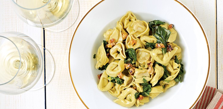 A bowl of tortellini with Crème Fraîche, Swiss Chard, and Toasted Walnuts