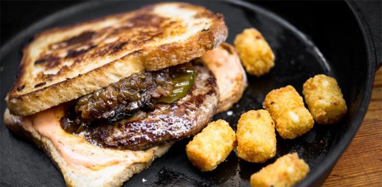 Melt Shop's Burger Melt and Tater Tots simmering in a pan.
