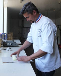 Affineur Rodolphe Le Meunier wraps a slice of Puits d'Astier at his aging caves near Tours, France