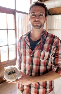 Oriol Artúnez with a wheel of his namesake cheese.