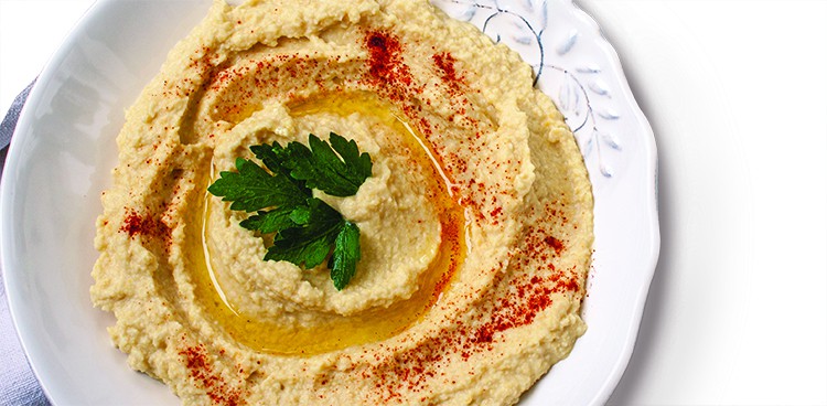 Home classic hummus with celery, pitoy.Vid top on gray concrete background. Vegan Food Concept.Home classic hummus with celery, pita. View top on gray concrete background. Vegan Food Concept.